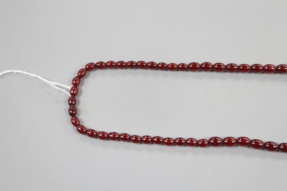 A single strand graduated simulated cherry amber oval bead necklace, 69cm, gross 54 grams.